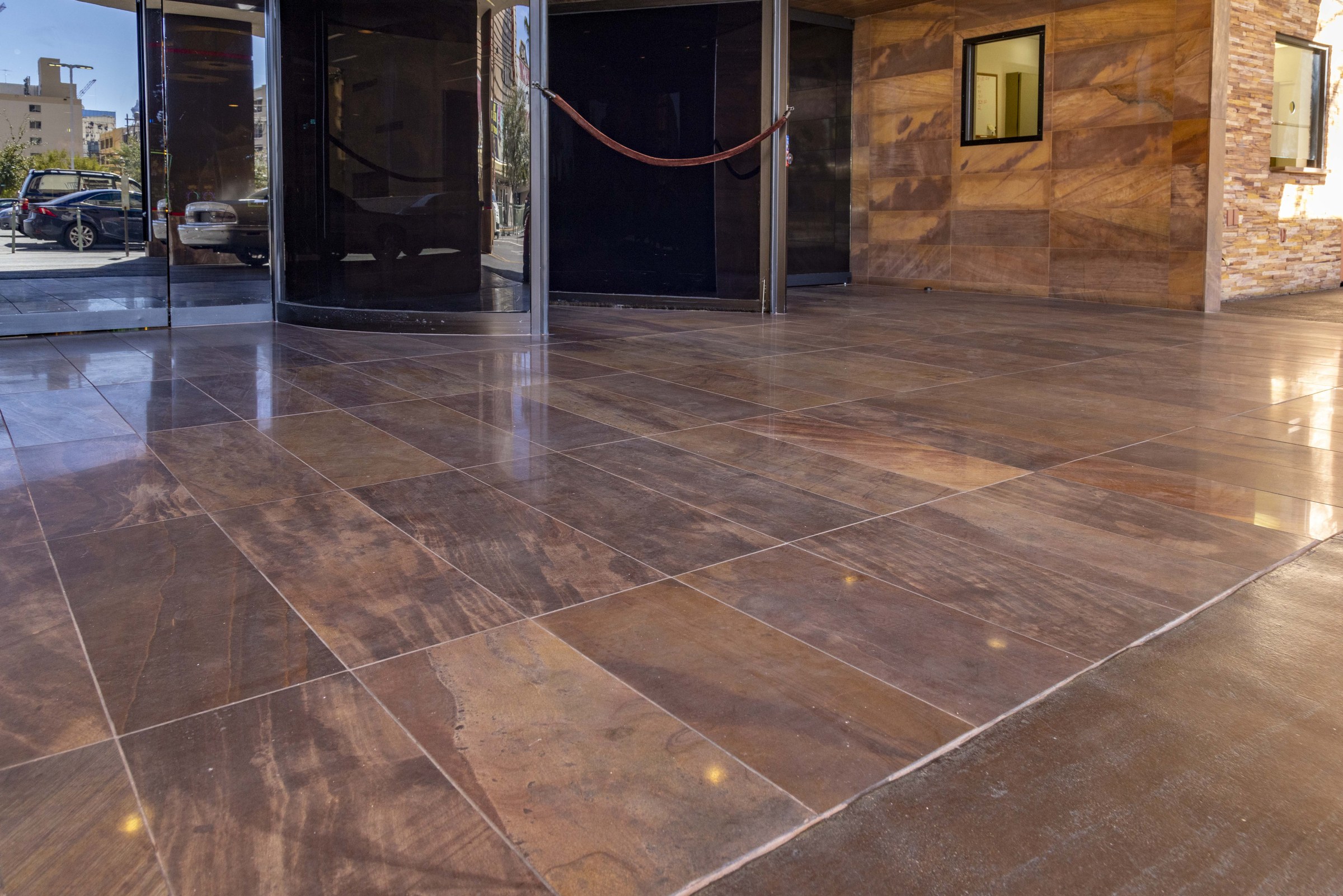 Polished stone tile entrance and revolving door at the Golden Gate Hotel porte cochere.