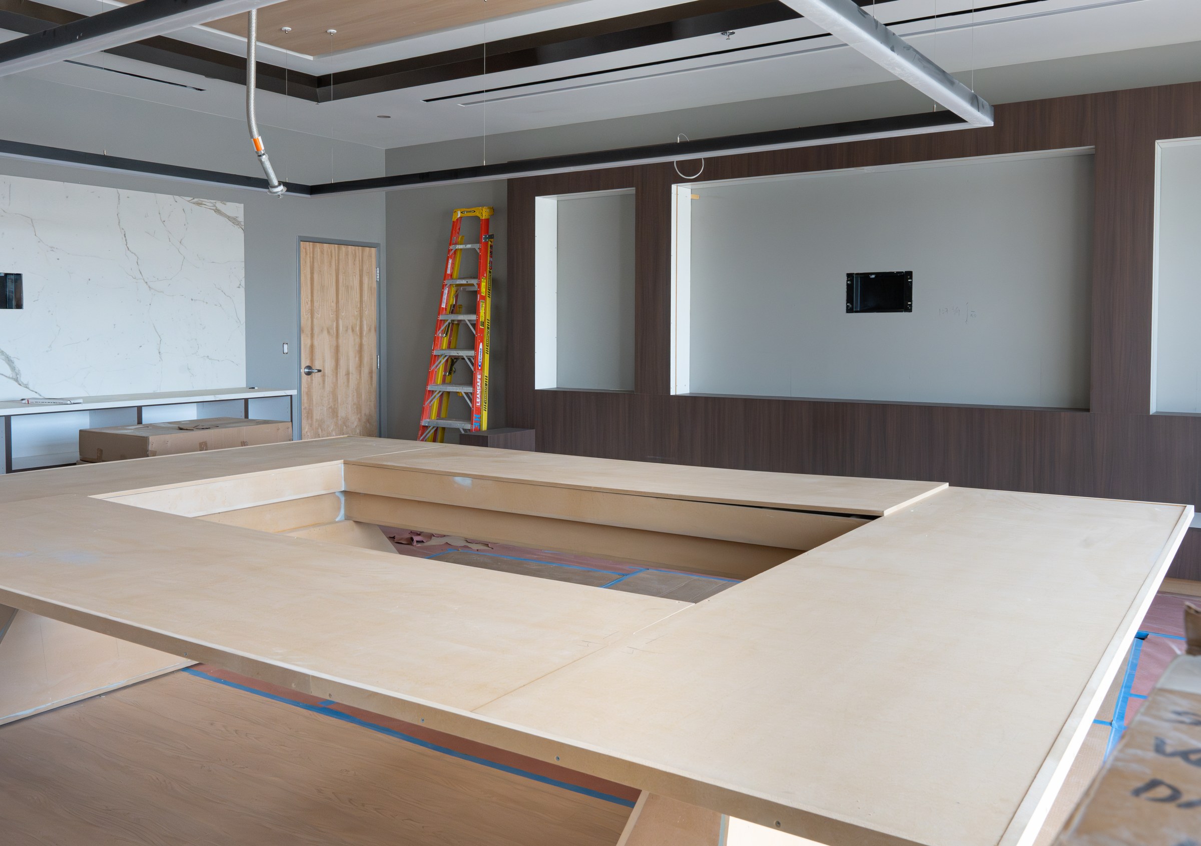 Custom-built wood conference table under construction in the Moen HQ conference room.