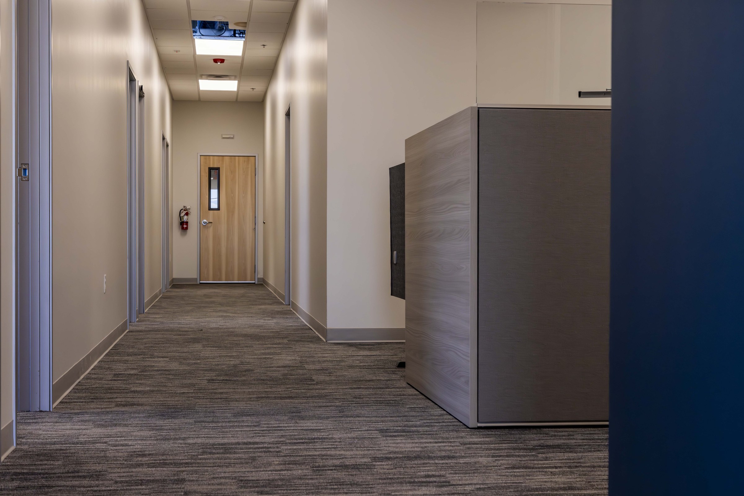 Open cubicle workstation area with new carpet tile and glass partition walls.